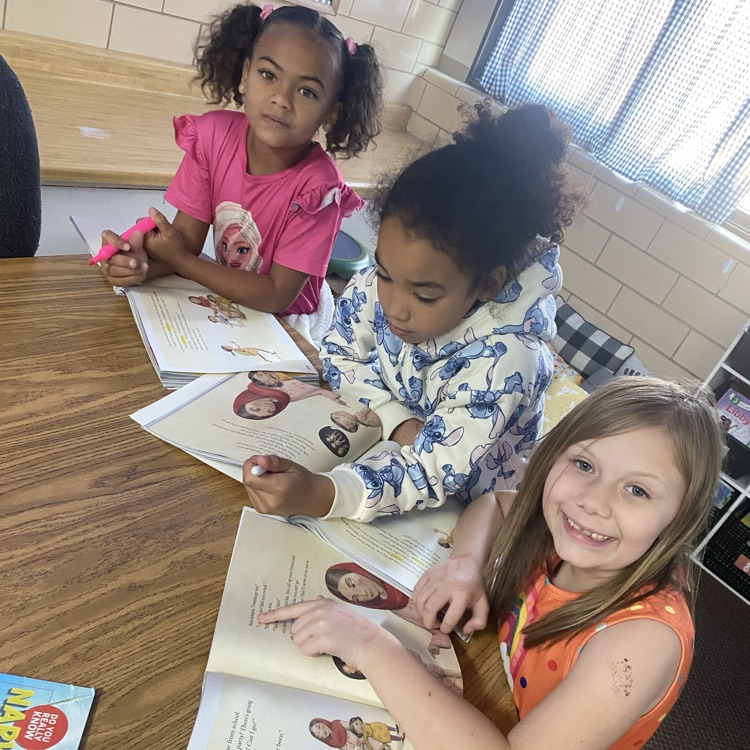 Students reading from their textbook