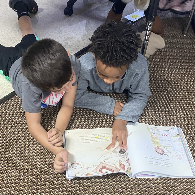 Students reading together from their textbook