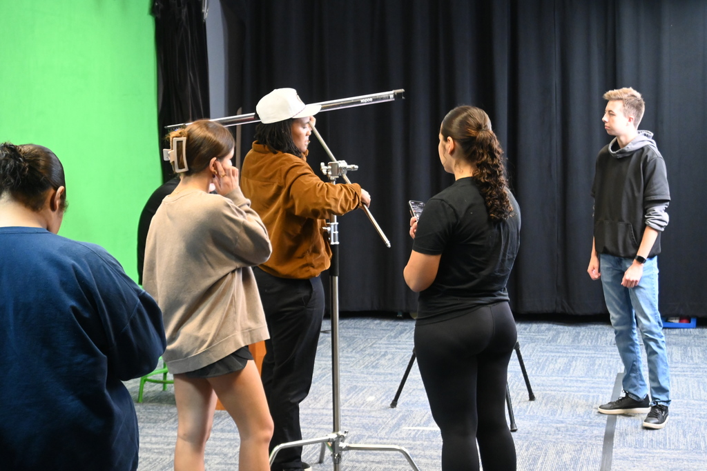 Kendricks instructs students on how to set up a light for filming.