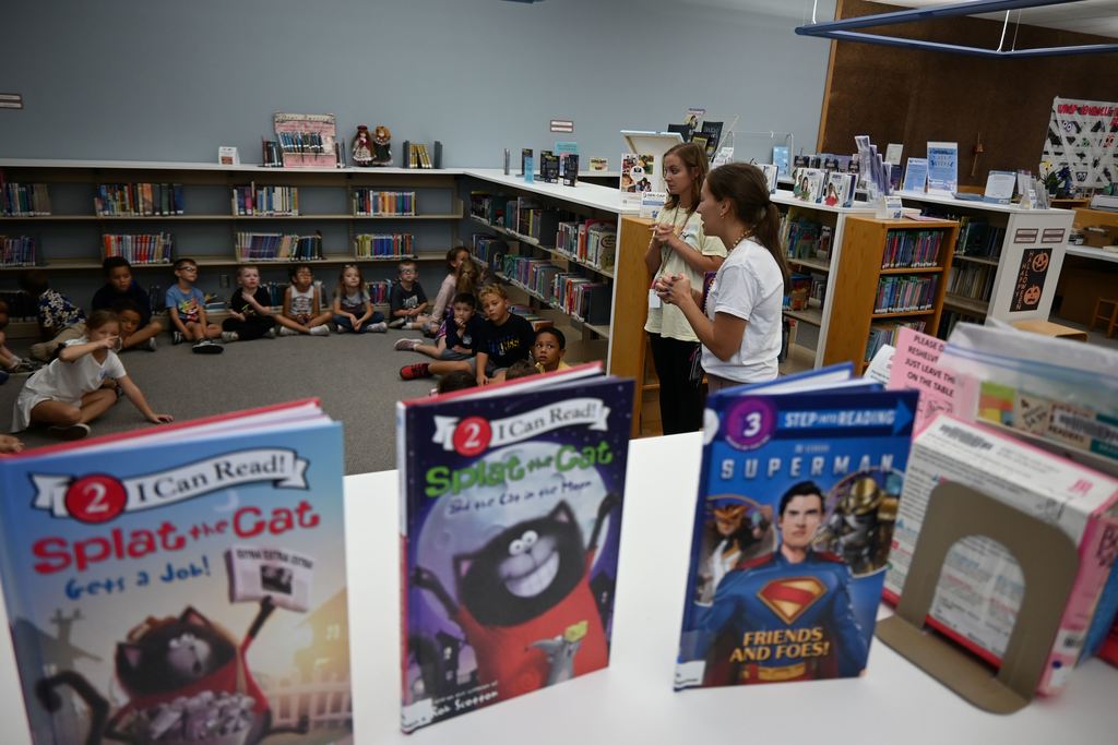 The teachers talk to students about looking at the books on the shelves, but not touching until they can come back with their adult to get a library card.