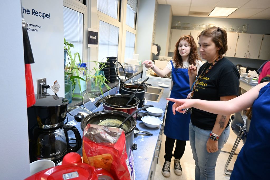 Students tell a teacher their favorite choices to encourage her which one to pick.