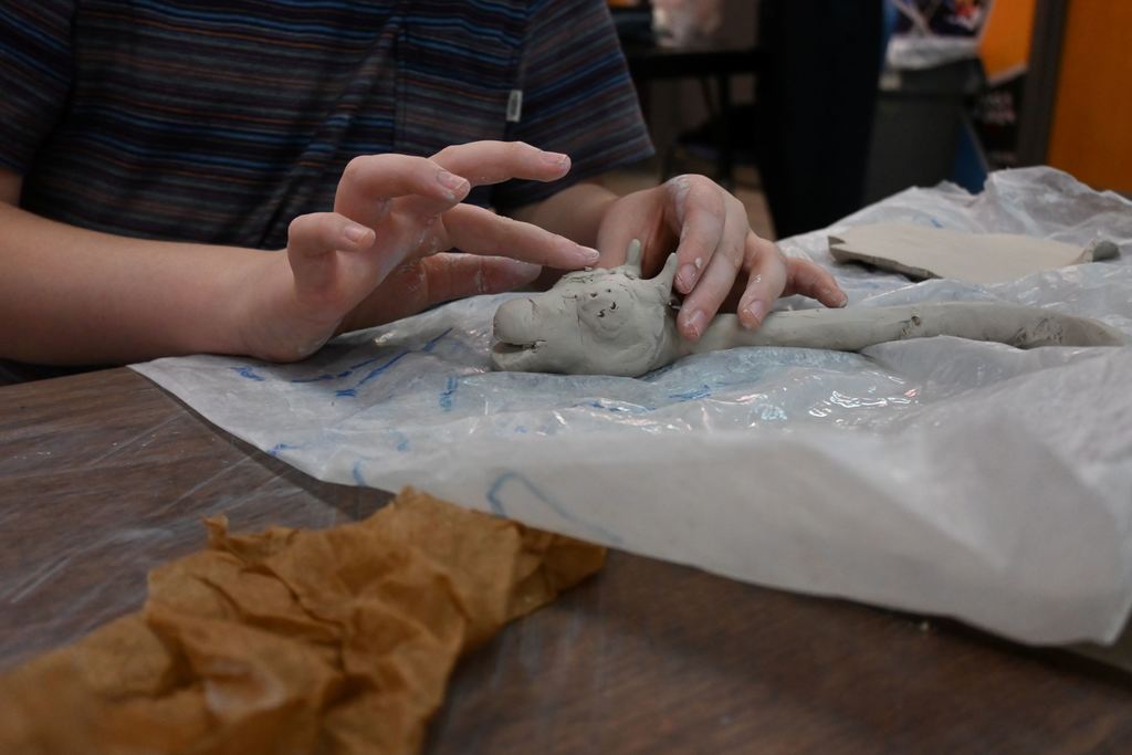 A student works on the eye of his dragon.