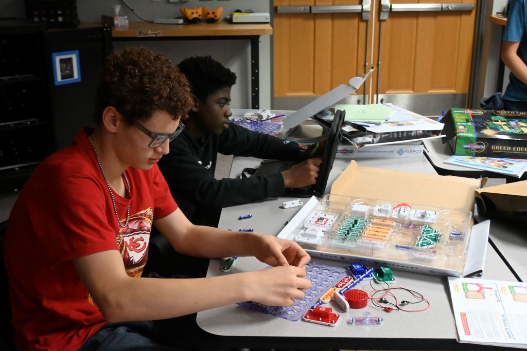 A student sets up circuits to make a helicopter prop spin.