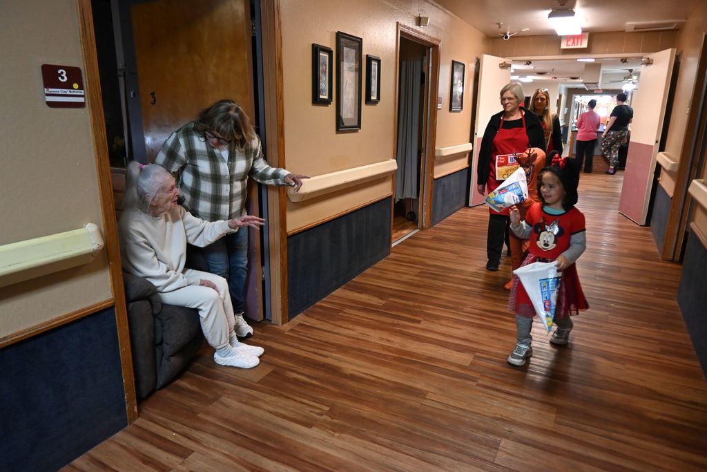 A resident waves at a little girl dressed as Mini Mouse.