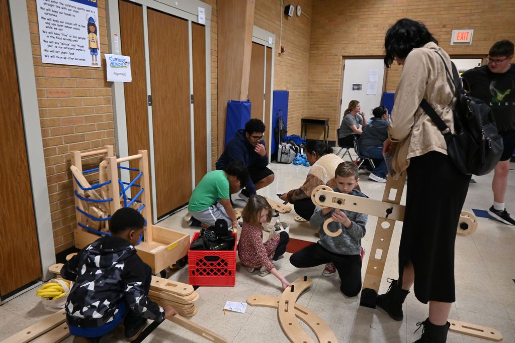 Kids build with a large, wooden construction set.