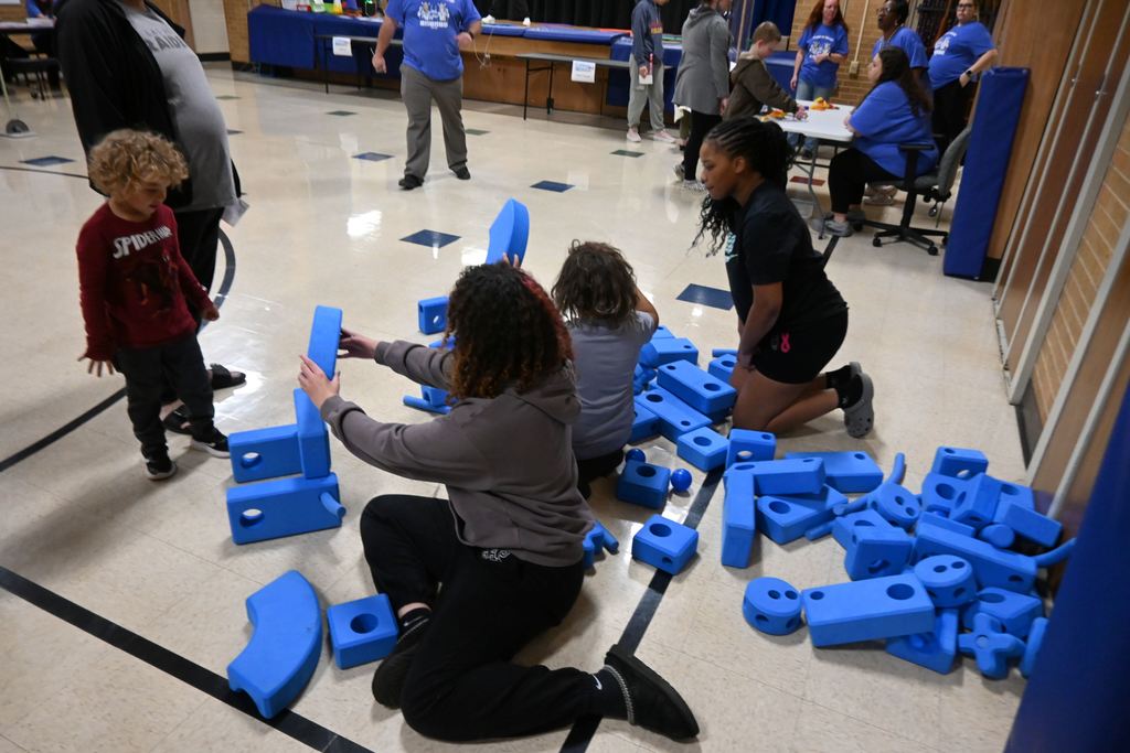 A family plays with large foam construction set pieces.