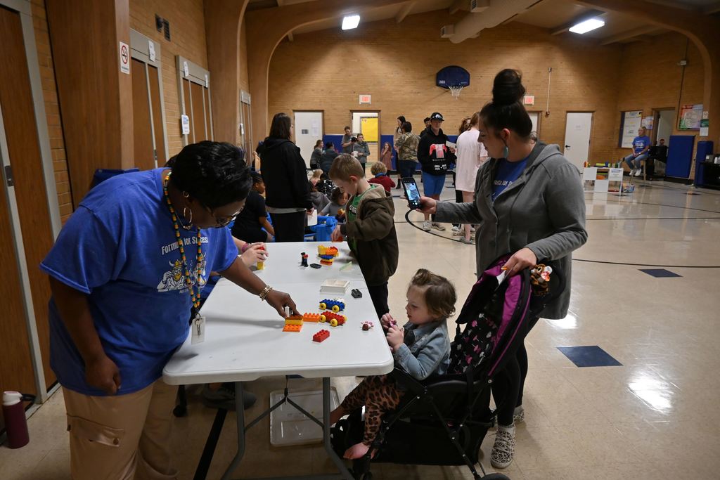 A family builds things at the LEGO table.