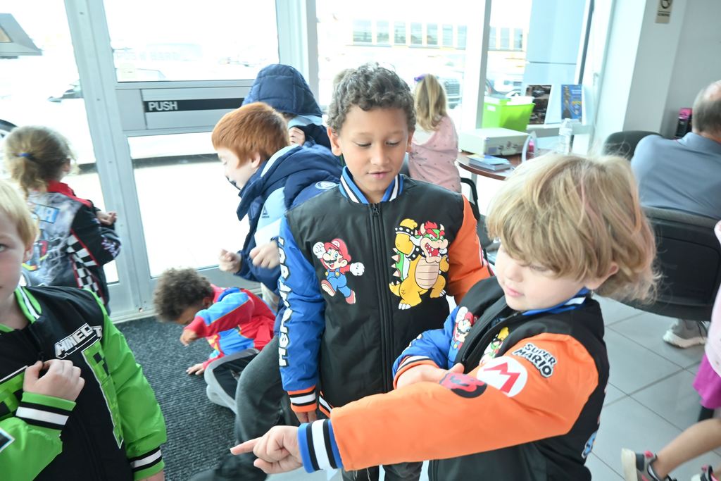 Two boys compare their Mario coats.