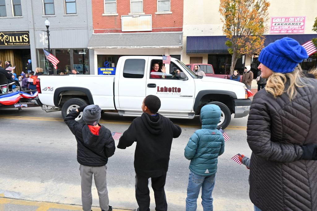 LCC President Mark Watkins waves a flag as he passes by in a truck.