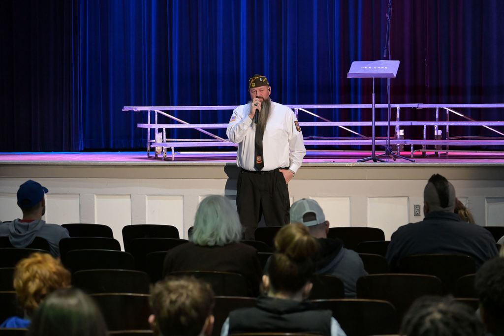 VFW 704 Post Commander Neil Springer speaks to Parsons Middle School students and staff, as well as other veterans in attendance.,
