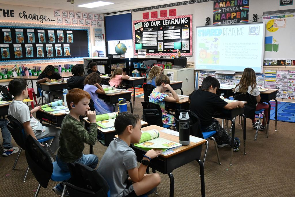 Students take turns reading segments of a story aloud during a shared reading exercise.