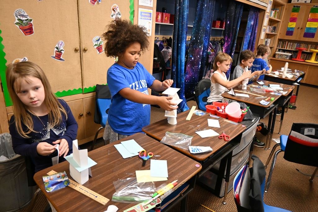 Students build towers out of nothing but note cards and paper clips.