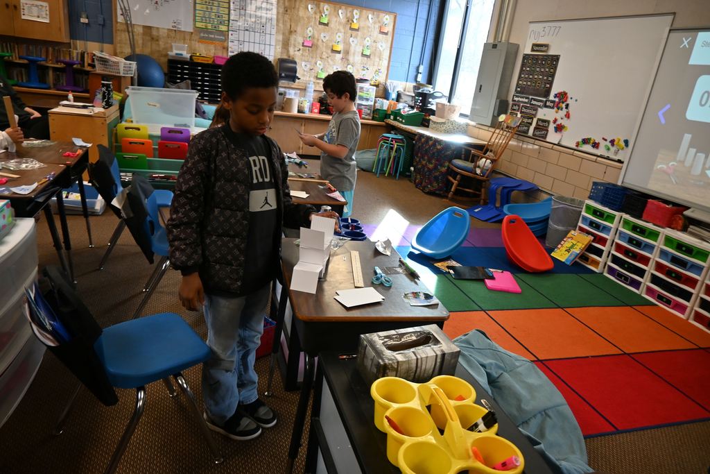 Students build towers out of nothing but note cards and paper clips.