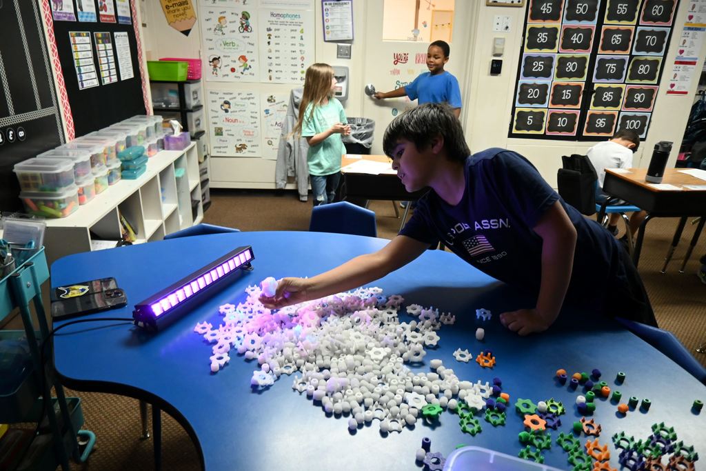 A student checks out his spinner under the black light.