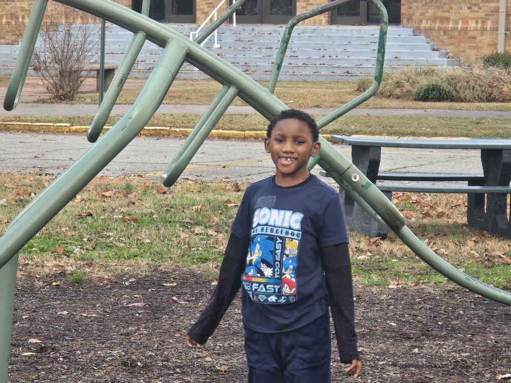 boy standing next to climber