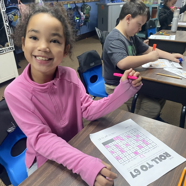student at a desk rolling dice to 67