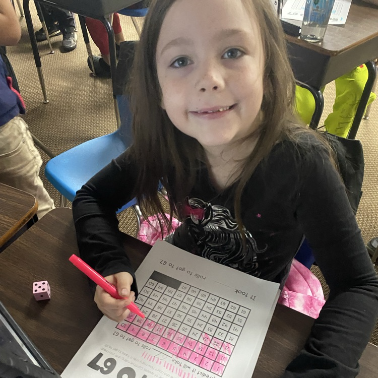 student at a desk rolling dice to 67