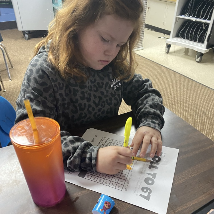 student at a desk rolling dice to 67