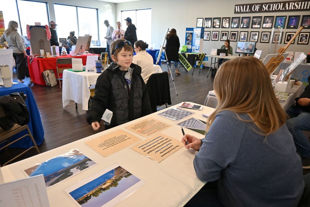 A boy visits with the Altamont City Manager about a project.