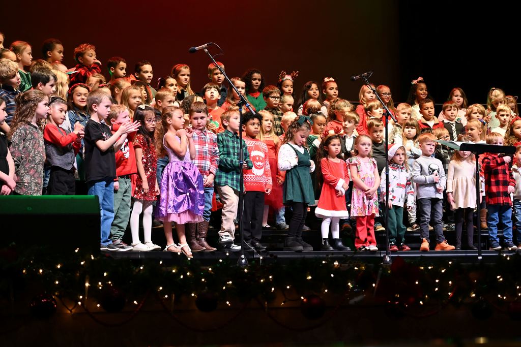 Lincoln children sing Christmas songs on stage.