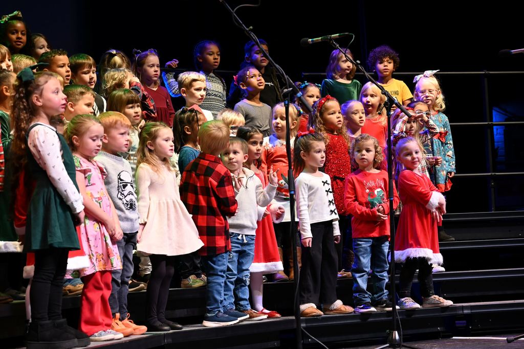 Lincoln children sing Christmas songs on stage.
