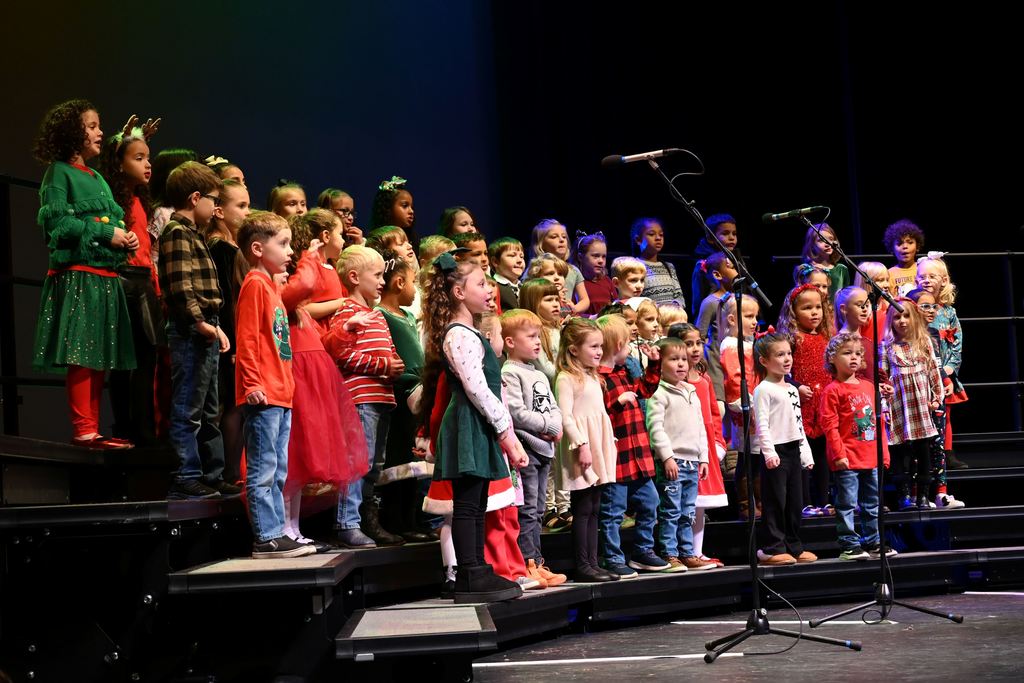 Lincoln children sing Christmas songs on stage.