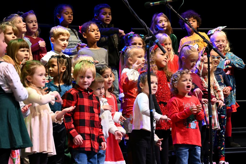 Lincoln children sing Christmas songs on stage.