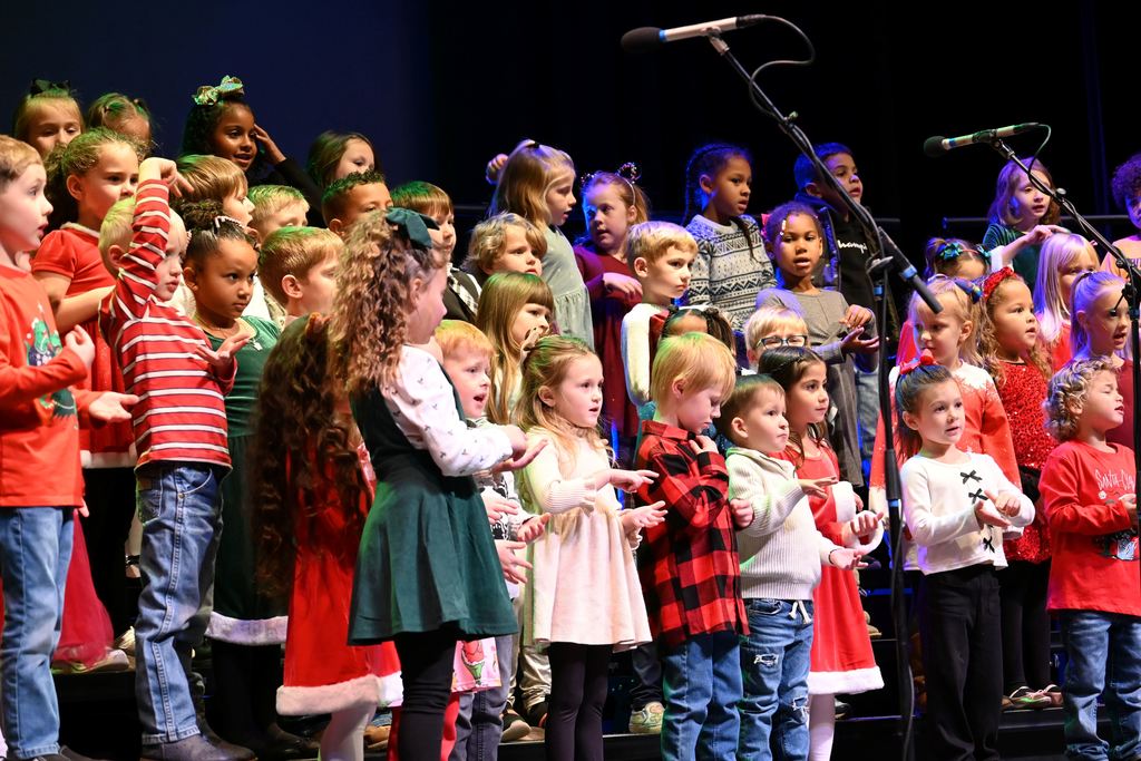 Lincoln children sing Christmas songs on stage.