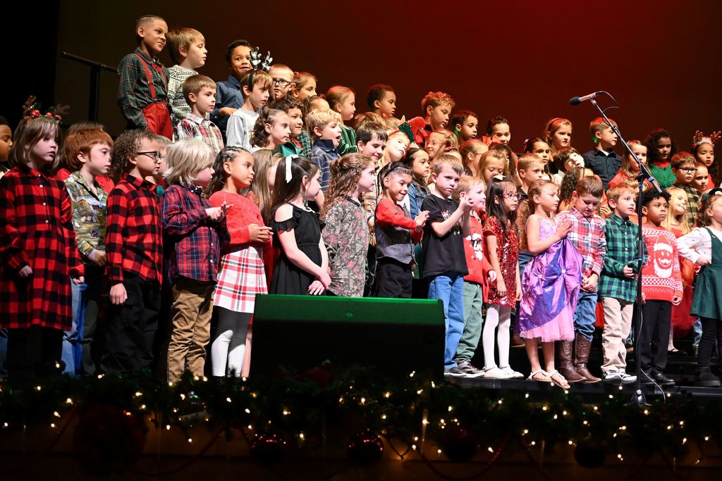 Lincoln children sing Christmas songs on stage.