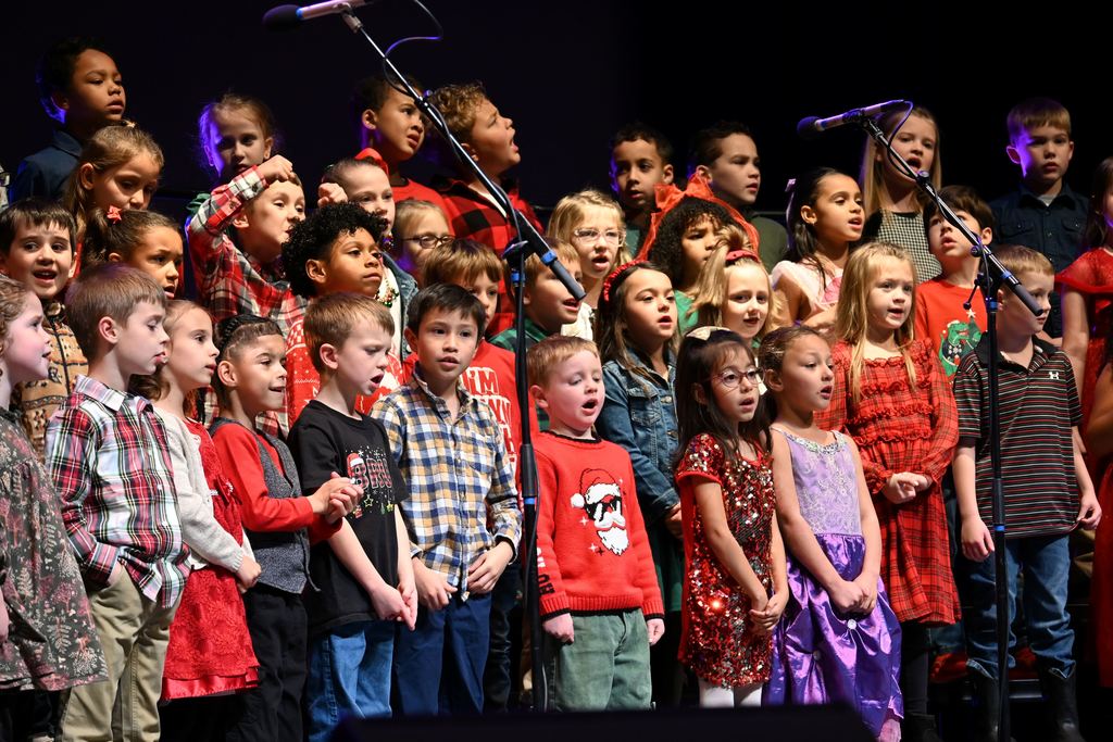 Lincoln children sing Christmas songs on stage.