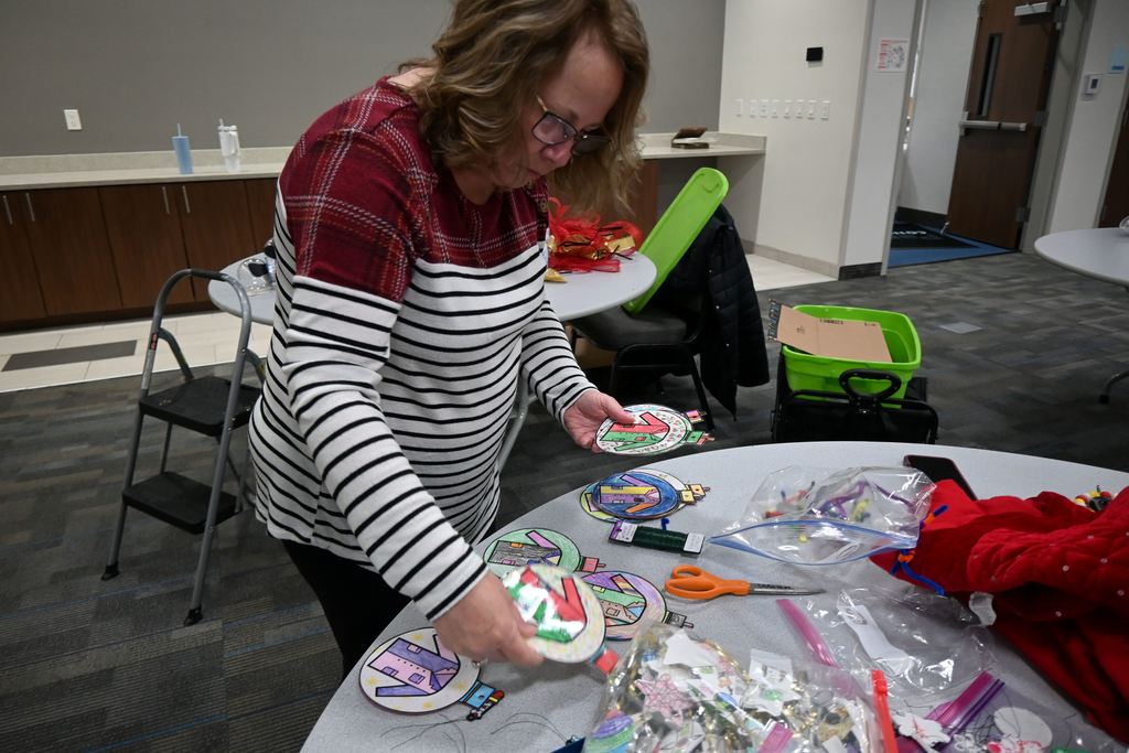 A staff member sorts through the lab coat decorations students colored.