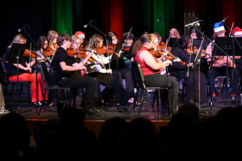 Orchestra students perform on stage.