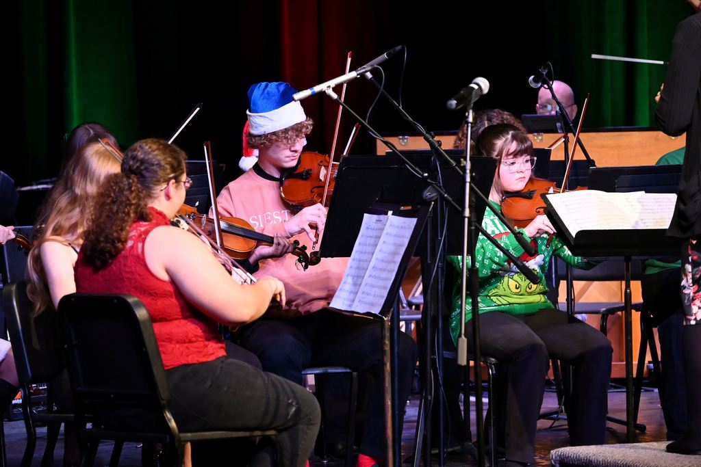 Orchestra students perform on stage.