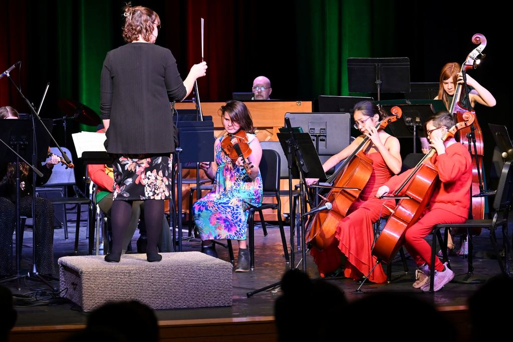Orchestra students perform on stage.