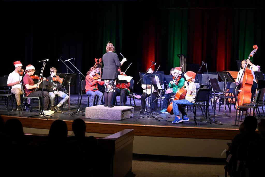 Orchestra students perform on stage.