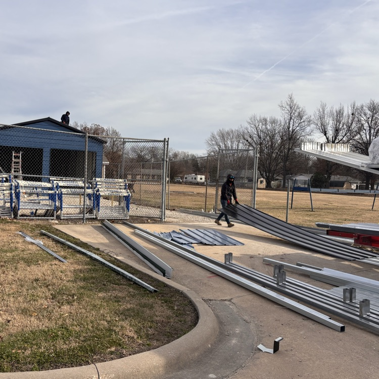 A worker pulls a piece of metal for the roof 