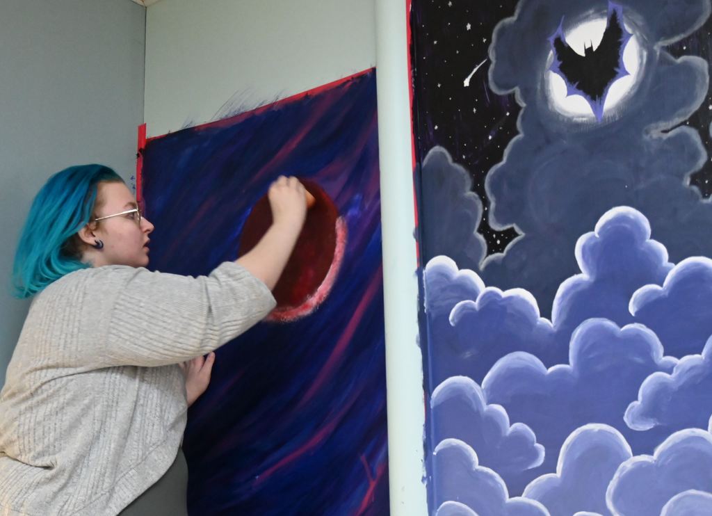 A stuidient paints her mural.