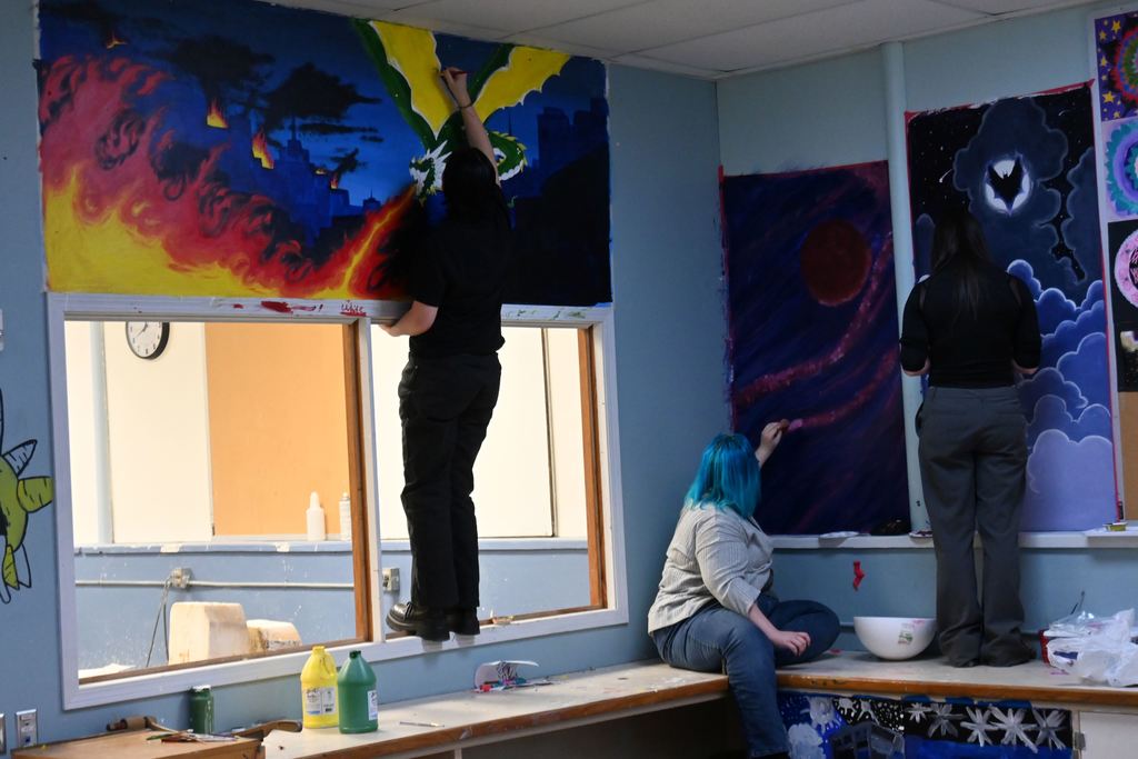 Students work on separate murals in the art room.