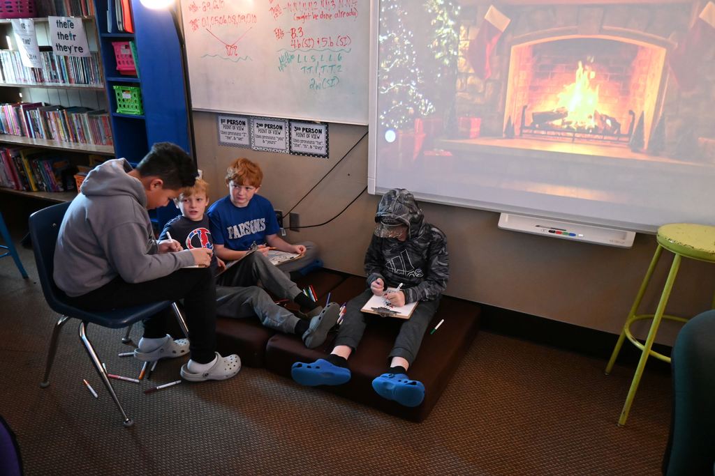 Boys sit in a group and color Christmas pages.
