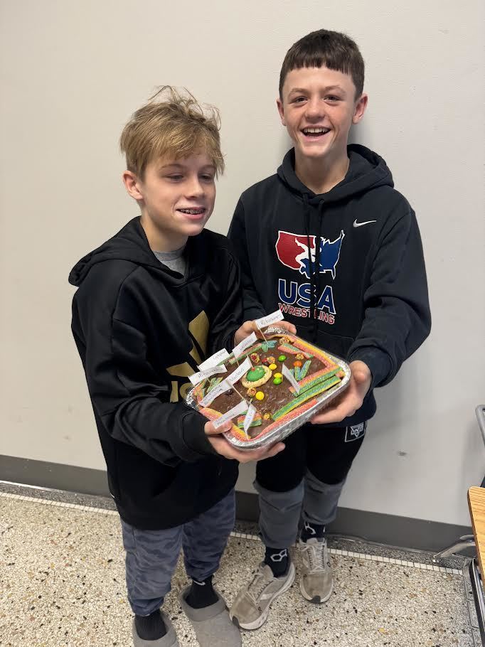 Two students  hold  up  their cell model.