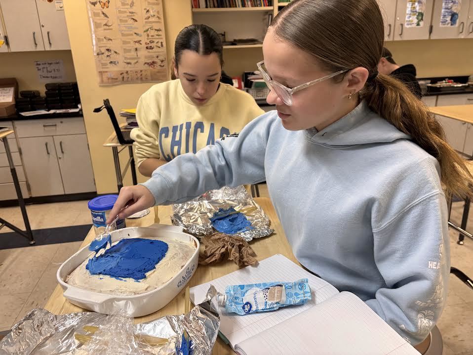 Two girls work on their edible cell model.
