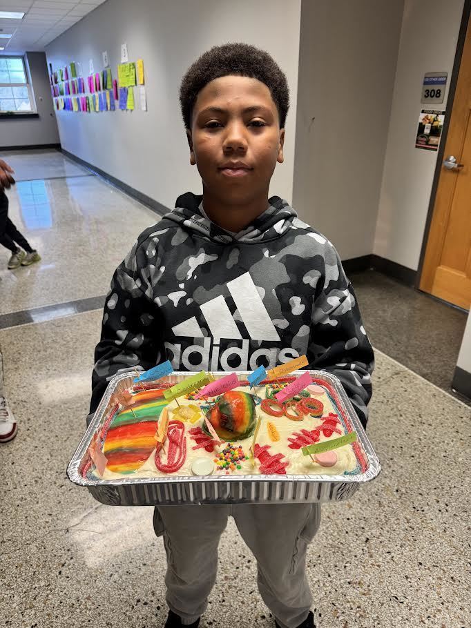 A young man holds up his edible  cell model