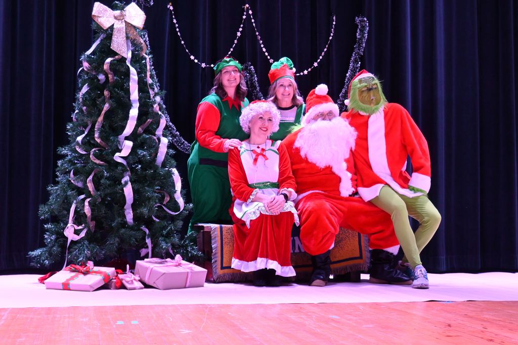 Mr. and Mrs. Santa, elves and the Grinch pose for a photo.