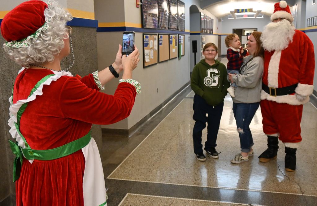 Mrs. Clause grbs oa photo of Santa with a family.