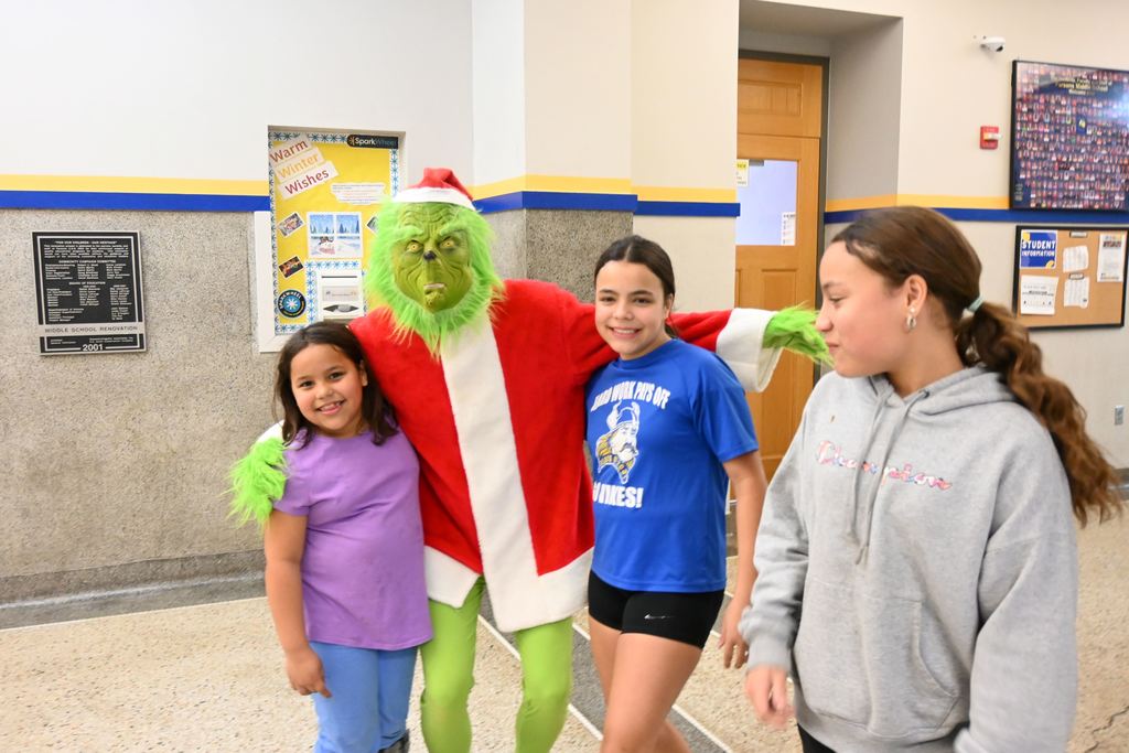 A fmily poses for a photo with the Grinch.