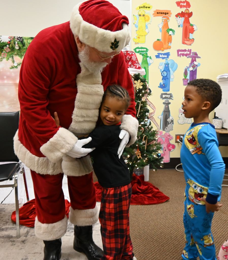 A child hugs Santa.