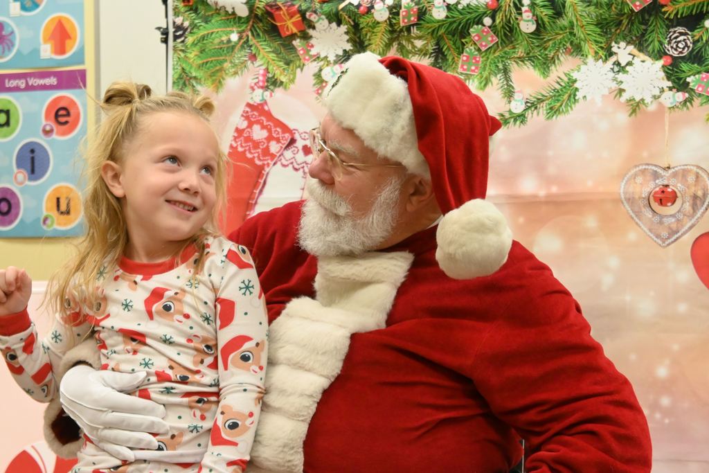 A little girl visits with Santa.