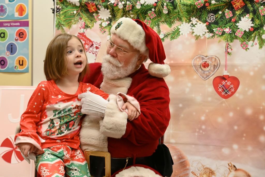 A little girl visits with Santa.
