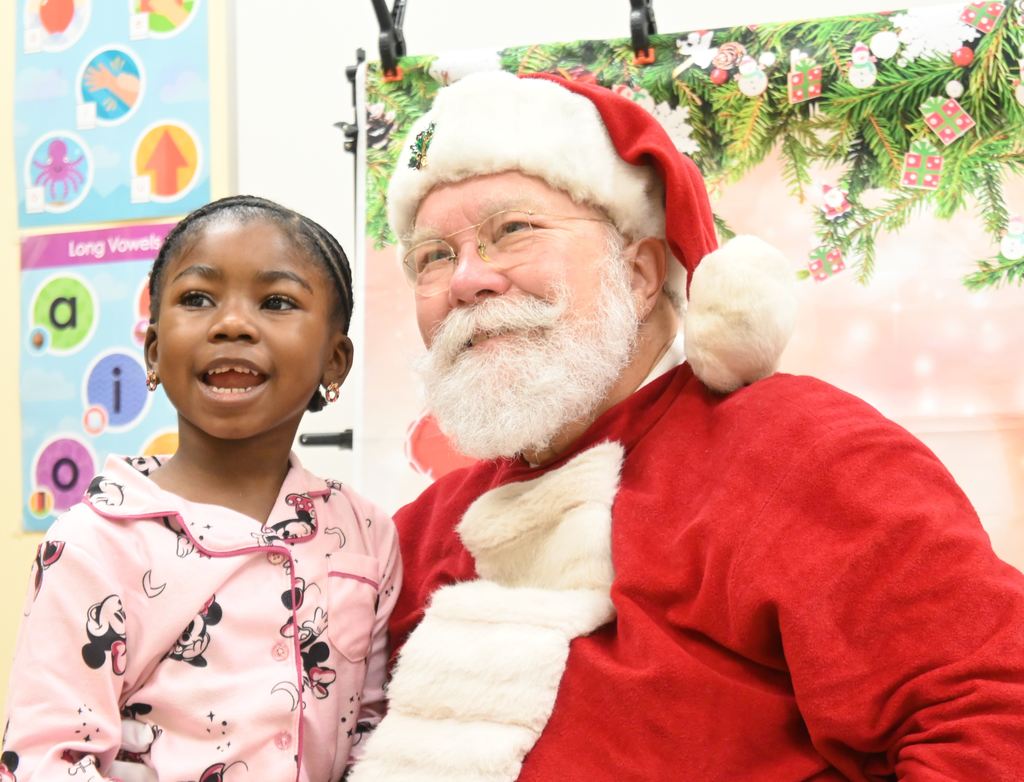 A little girl visits with Santa.