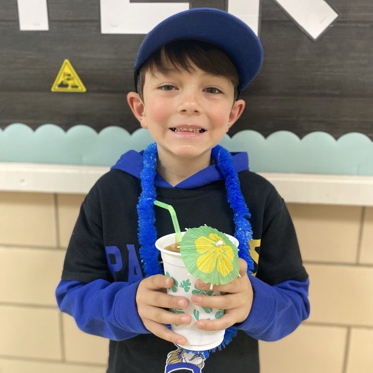 student holding a cup and wearing a lei 